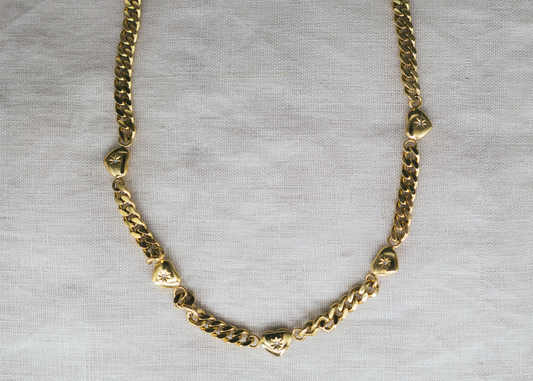 Lover’s Link -&nbsp;Gold-Plated Heart Charm Necklace. Gold chain necklace on a gray background