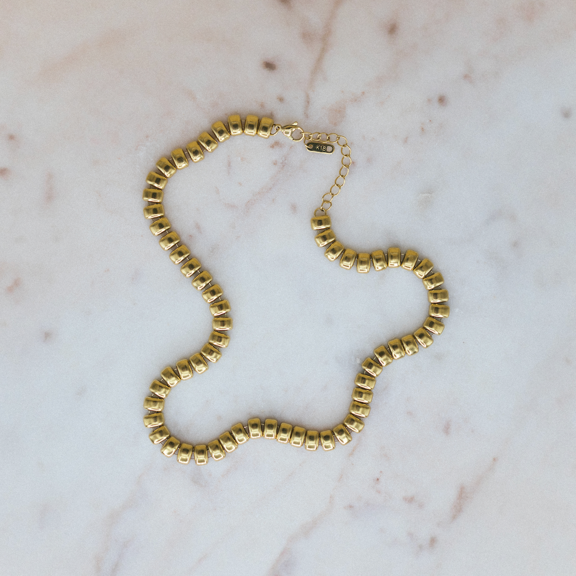 Gold necklace on a marble surface