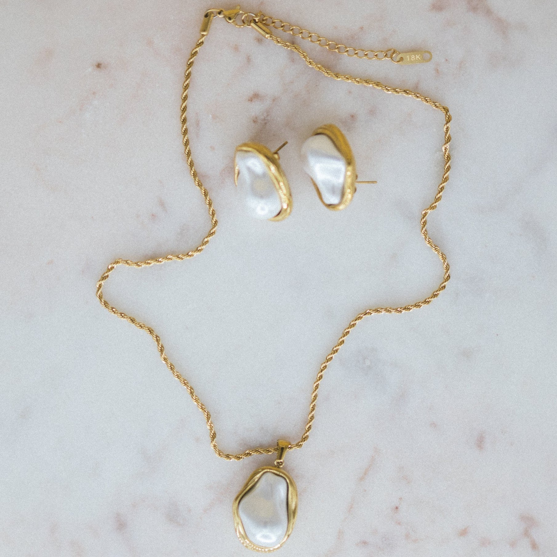 Golden Tides Necklace and earrings on a marble surface